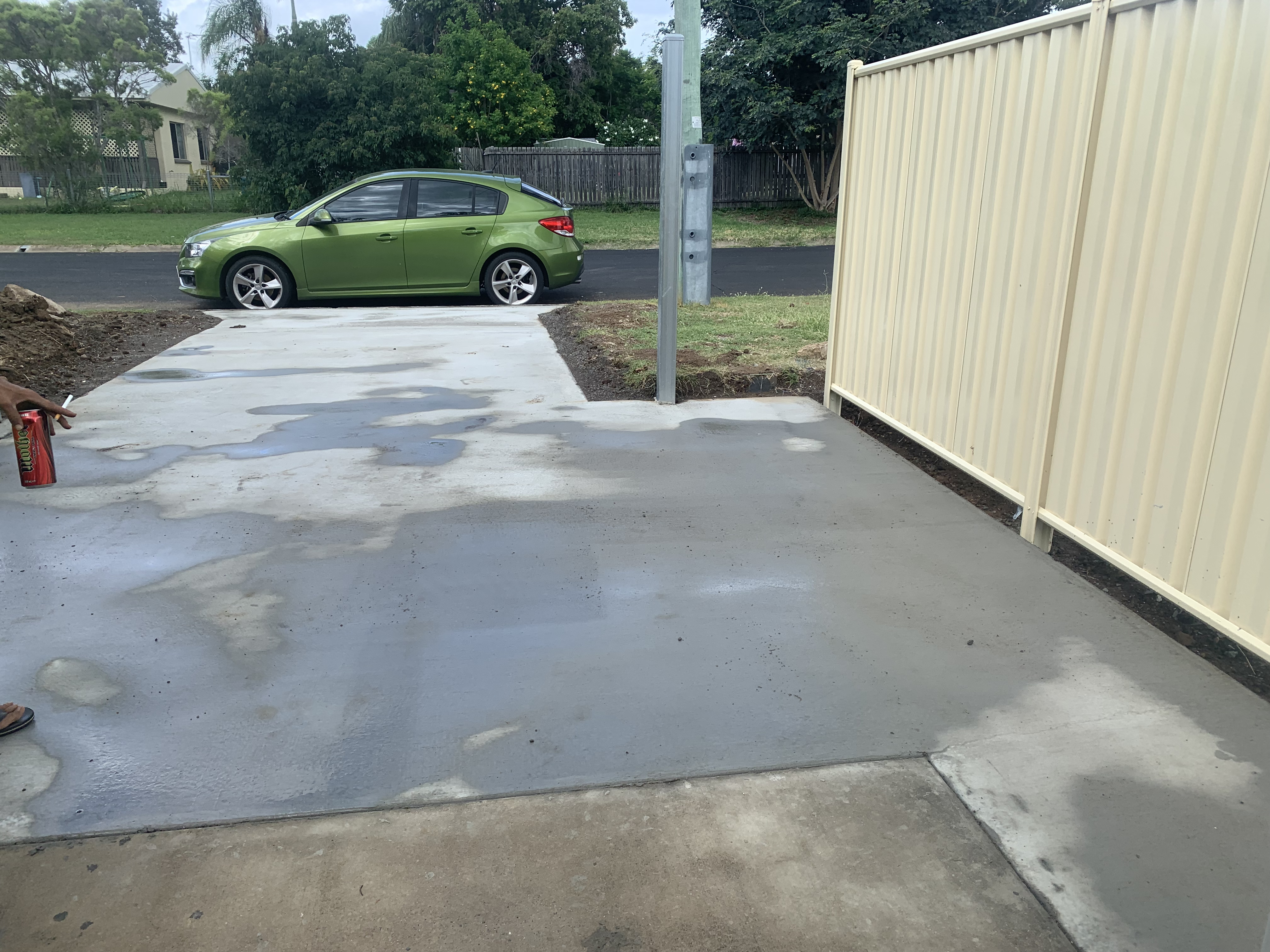 Fresh residential concrete driveway — slab with moisture curing visible